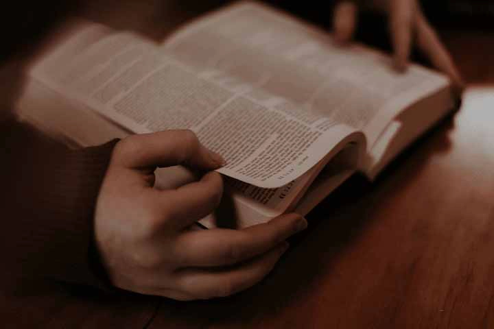 Hands holding religious text